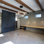 森田電機様の新しい事務所内装。高い天井と木の梁、スタイリッシュな照明が特徴的な開放感あふれるワークスペース。